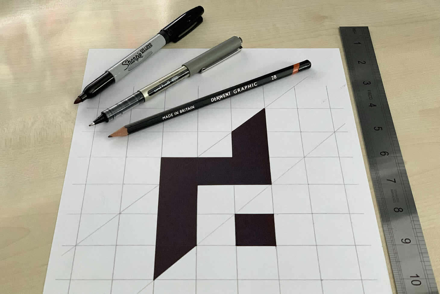 Grid sketch of the DESIGN DPI brand mark with ruler, pens and pencils